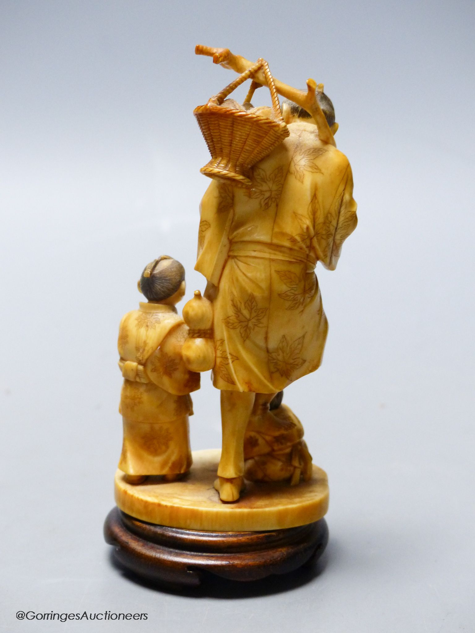 A Japanese ivory okimono of a peach seller